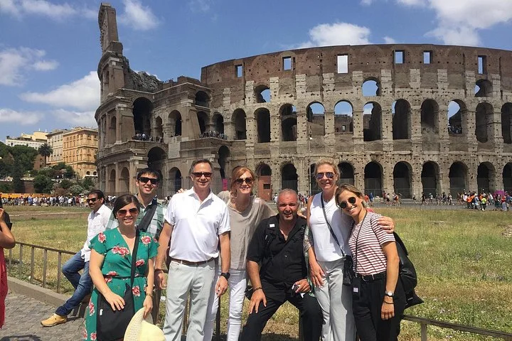 A group posing outside the Colosseum
