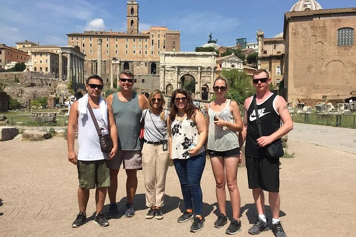 Visitors standing among Roman Forum temples