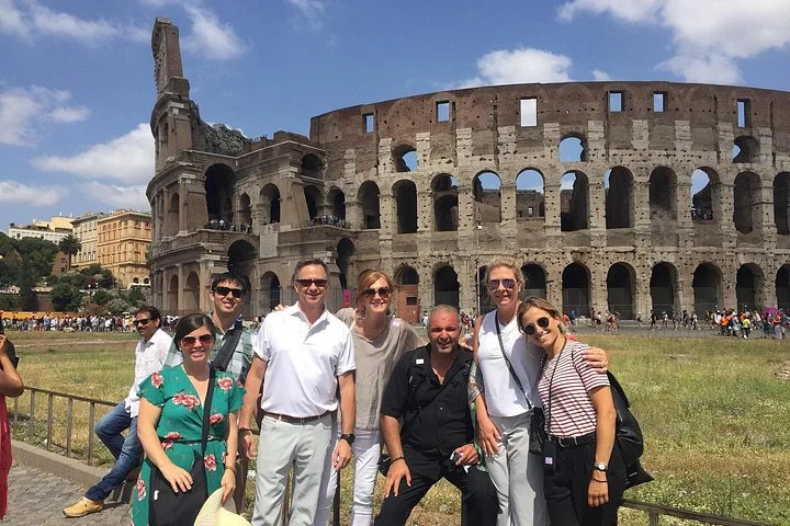 A group posing outside the Colosseum