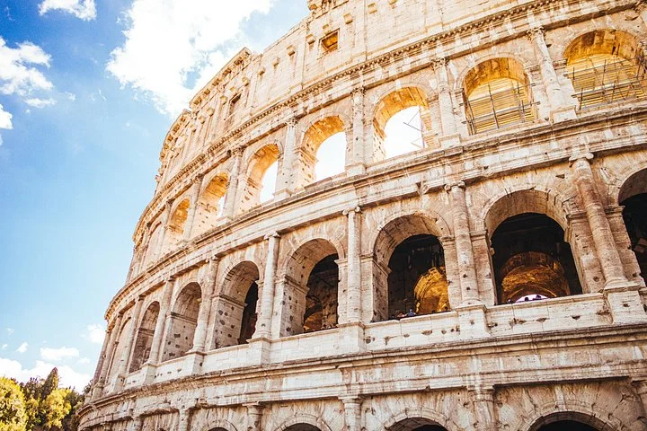 Sunlit stone arches of the Colosseum exterior