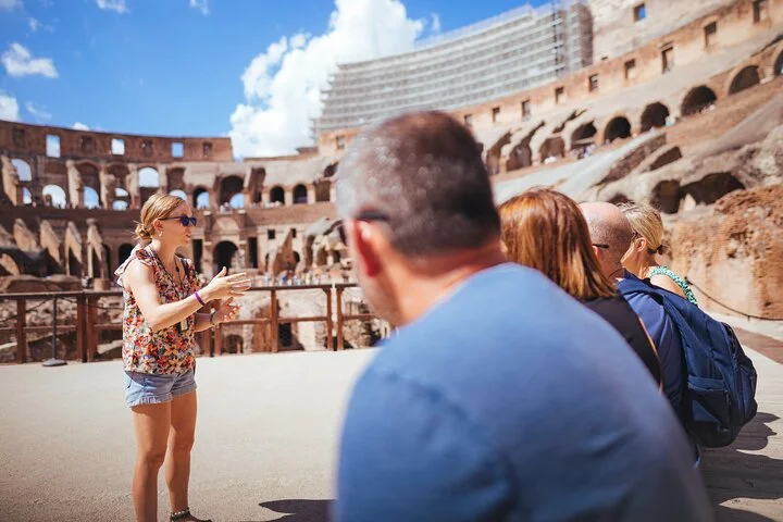 A guide addressing visitors on the arena floor