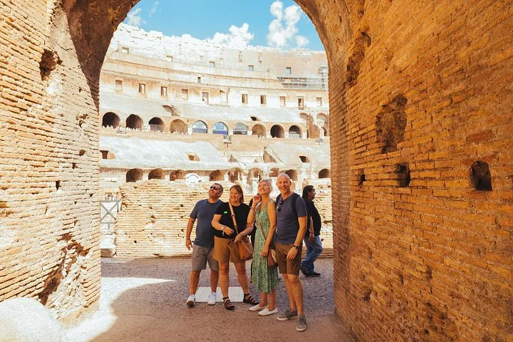 Visitors under a brick arch beside the arena