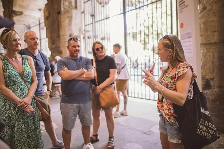 A guide speaking in a Colosseum entrance arcade