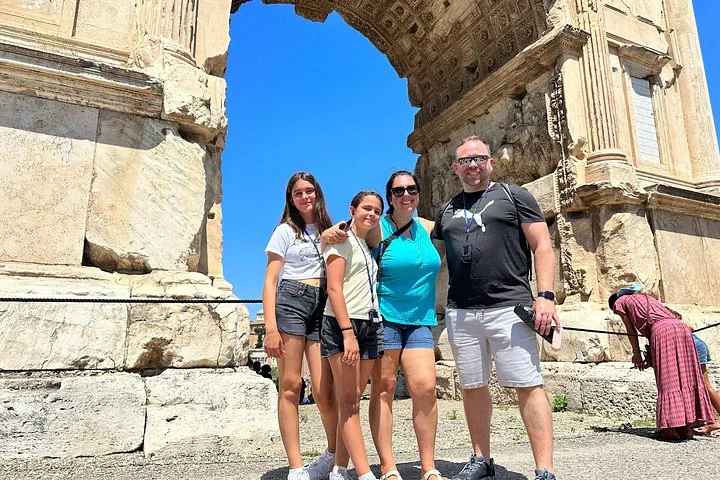 Visitors beside an ancient Roman Forum temple doorway
