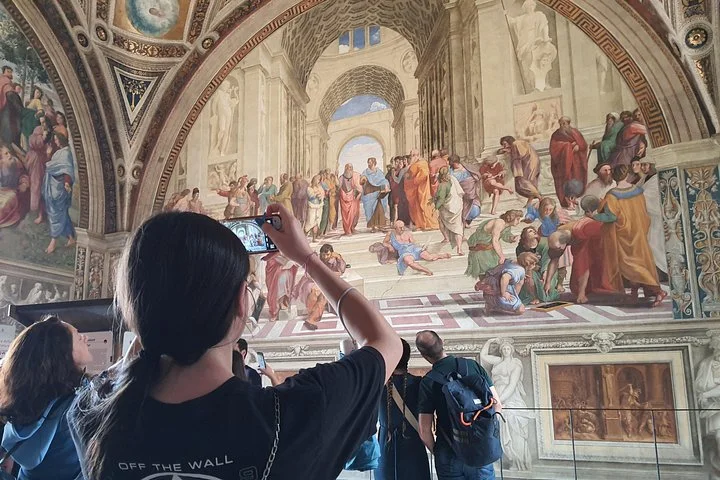 Visitors studying a Raphael Rooms fresco