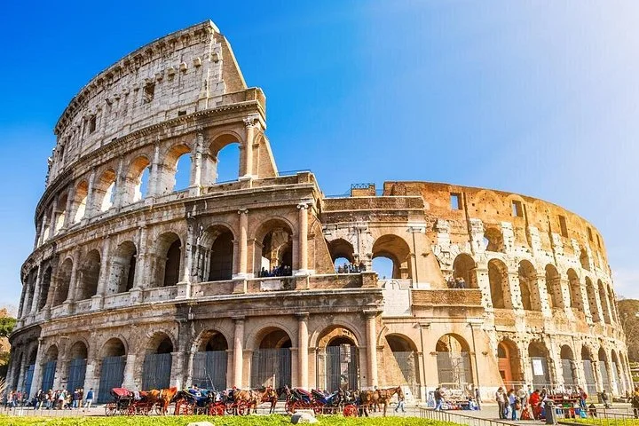Colosseum exterior arches beneath a blue sky
