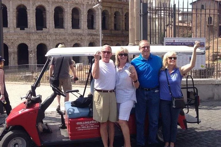Visitors beside a golf cart outside the Colosseum