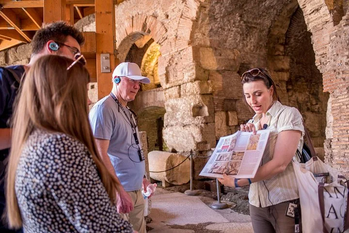 A guide explaining an illustration beside ancient arches