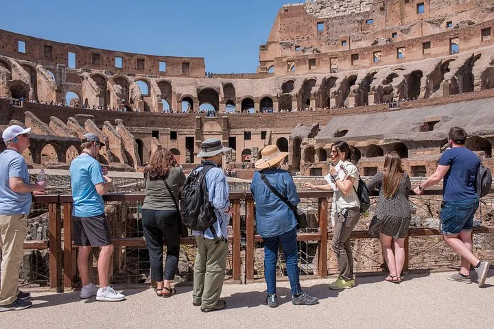 A group listening beside the Colosseum arena railing