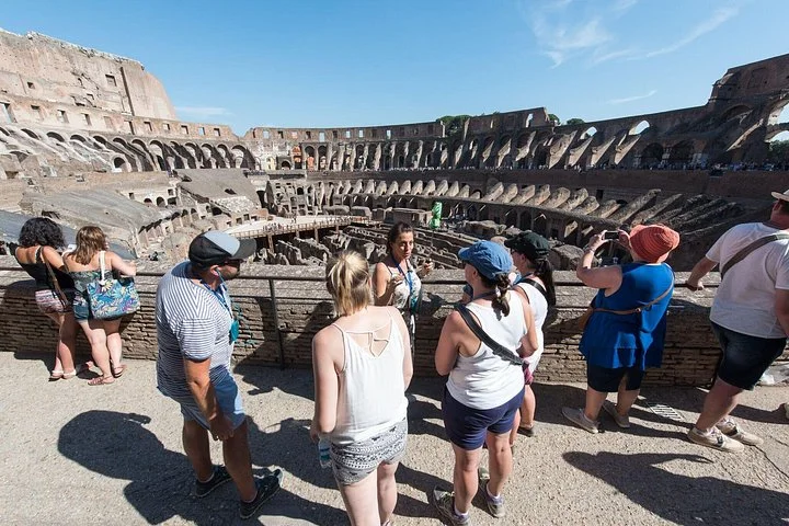 Visitors listening to a guide at a Colosseum viewpoint