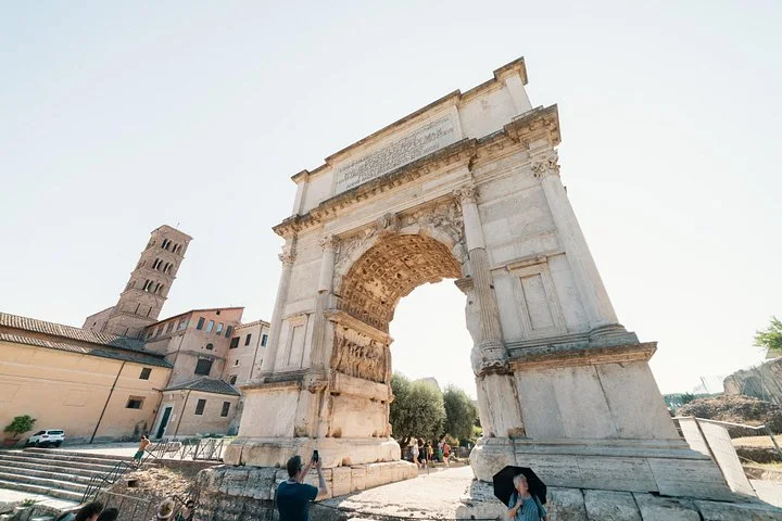 An ancient triumphal arch rises above the Roman Forum.