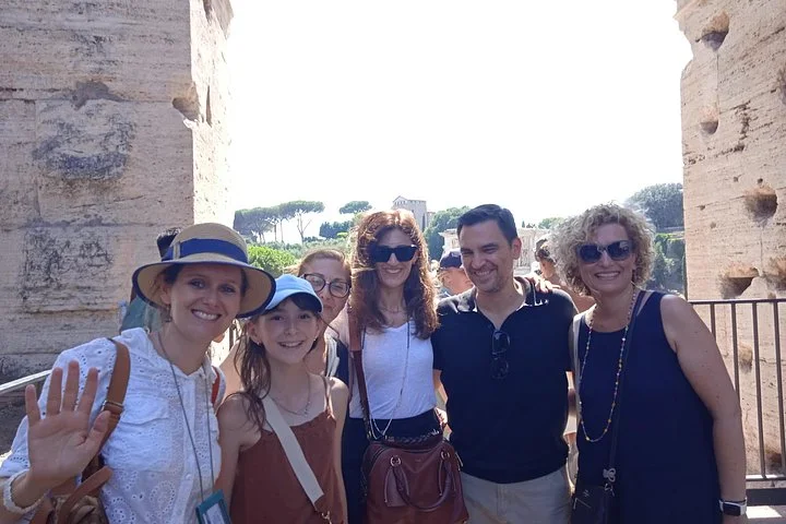 Visitors posing in a Colosseum outer arcade