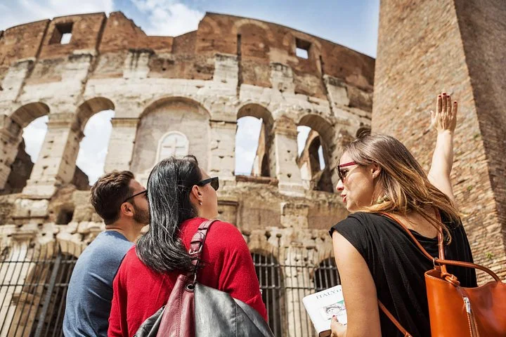 A guide speaking beside the Colosseum exterior