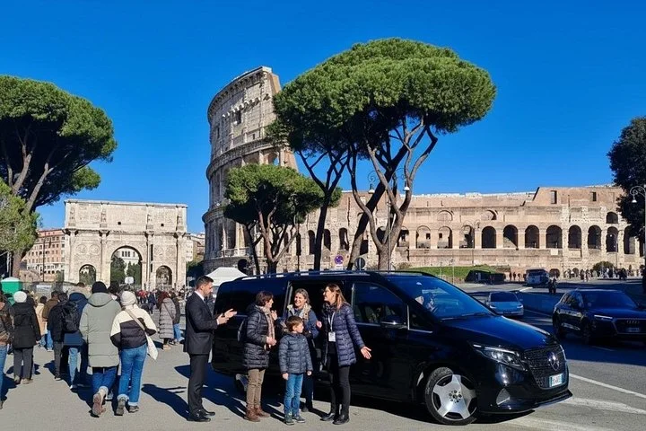 Visitors beside a private-tour van and the Colosseum