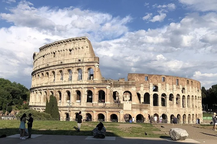 The Colosseum exterior beneath scattered clouds