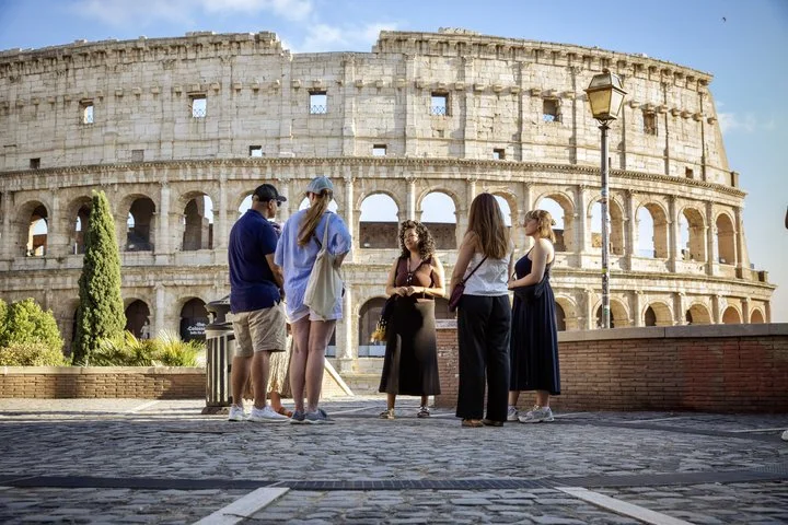 A guide and visitors outside the Colosseum