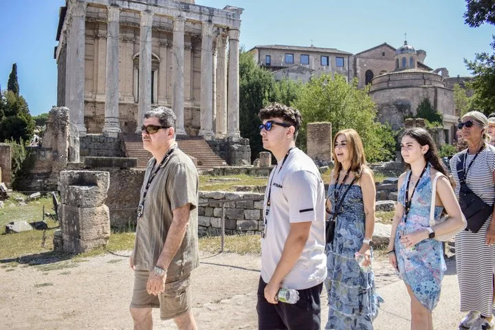 Visitors beside the Temple of Antoninus and Faustina