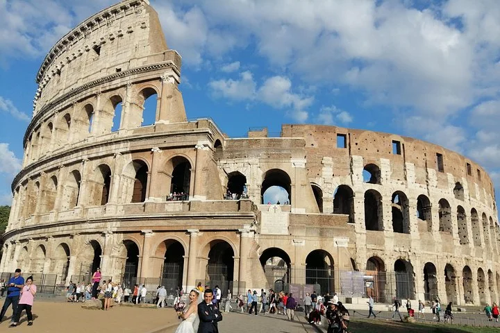 The Colosseum exterior beneath white clouds