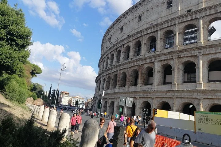 The curved Colosseum facade beside a busy path