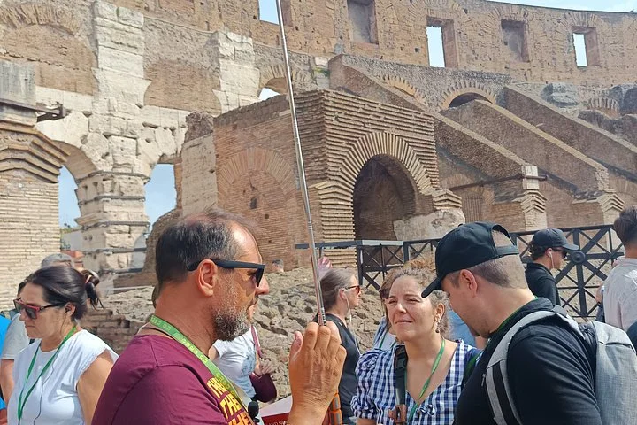 A guide addressing visitors inside the Colosseum