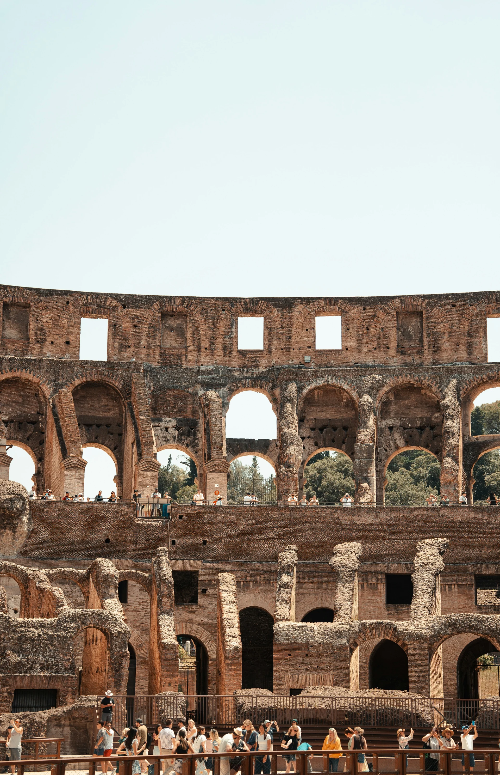 Warm brick arches and visitors inside the Colosseum